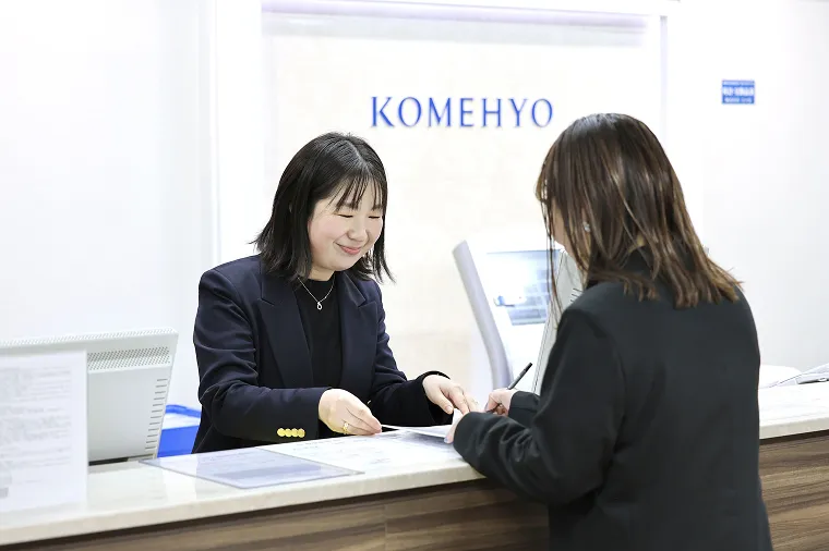 買取受付でお客様に伝票を渡すスタッフ